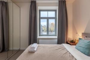 um quarto com uma cama e uma janela em Ķīpsala apartments with free parking em Riga