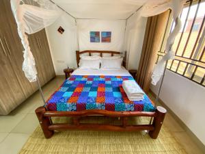 a bedroom with a bed with a colorful quilt at The Lovely Homestay in Kampala