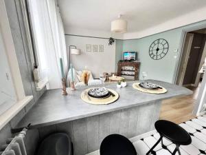 sala de estar con barra con sillas y mesa en Le Cosy, en Calais
