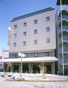 Blossom Hotel Hirosaki في هيروساكي: مبنى كبير مع الكثير من النوافذ