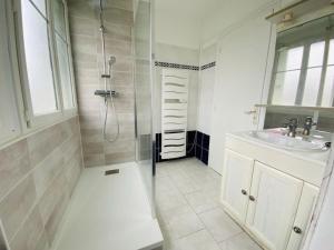 a white bathroom with a shower and a sink at Chtx bel appart 3 chb parking in Châteauroux
