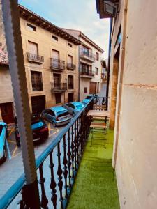 un balcón de un edificio con coches aparcados en una calle en Apartamento Esencia San Vicente de la Sonsierra, en San Vicente de la Sonsierra