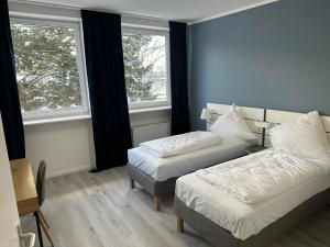 een kamer met 2 bedden en 2 ramen bij Hami Home Hamburg in Hamburg