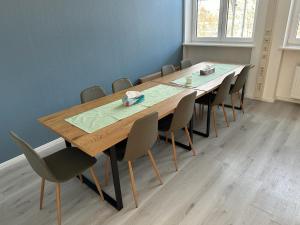 een conferentieruimte met een lange houten tafel en stoelen bij Hami Home Hamburg in Hamburg