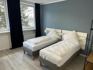 a bedroom with two beds and two windows at Hami Home Hamburg in Hamburg