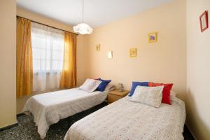 1 dormitorio con 2 camas y ventana en Casa Fefa, en Candelaria