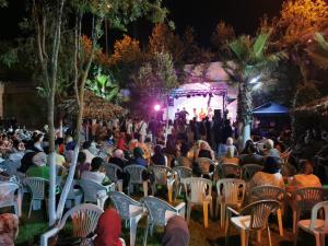 a crowd of people sitting in chairs in front of a stage at Chez Marya Asilah Marina Golf uniquement famille in Asilah