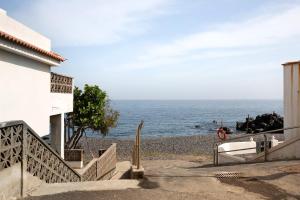 a beach with a building and the ocean at Casa Fefa in Candelaria