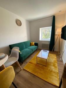 uma sala de estar com um sofá verde e uma mesa em T2 Chic Green & Yellow em Mazamet