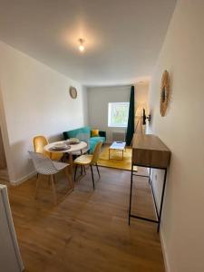 uma sala de estar com uma mesa e cadeiras e um sofá em T2 Chic Green & Yellow em Mazamet