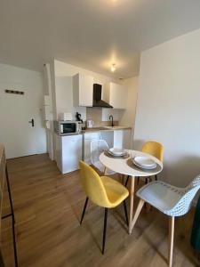 uma cozinha e uma mesa e cadeiras num quarto em T2 Chic Green & Yellow em Mazamet