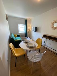 uma sala de estar com uma mesa e cadeiras e um piano em T2 Chic Green & Yellow em Mazamet