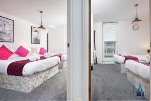 - une chambre avec 3 lits avec des oreillers roses dans l'établissement City View Apartments, à Birmingham