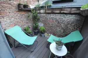 two chairs and a table on a deck with plants at Old Town - Lovely typical house in Lille