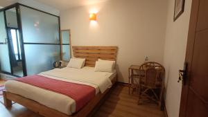 a bedroom with a large bed with a wooden headboard at Easy Homes - Ashok Stupa in Pātan