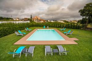 a group of chairs sitting around a swimming pool at GOLDNATURE in Gondomar
