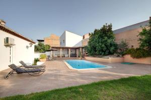 un patio con piscina y 2 sillas junto a un edificio en TESS Casa La Alcazaba de Serrato, en Serrato