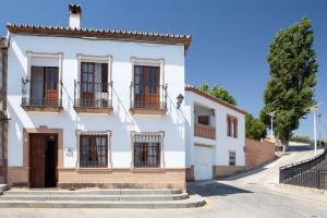 Casa blanca con ventanas y puerta en TESS Casa La Alcazaba de Serrato, en Serrato