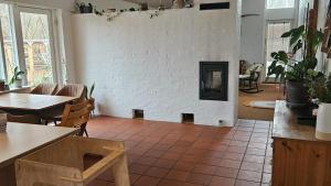 a living room with a white brick wall with a fireplace at Hjertevarm Oase: Harmoni og højt til loftet in Morud