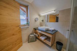ein Bad mit einem Waschbecken und einem Spiegel in der Unterkunft loisi's Boutiquehotel in Achenkirch