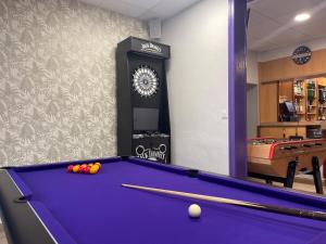 a billiard room with a pool table and a clock at Logis Hôtel Le Bocage in Montmarault