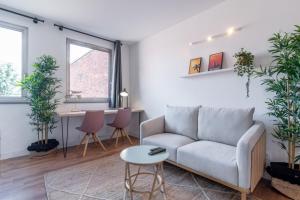 a living room with a couch and a table at Grand' Place of Lille - Superb designer apartment in Lille