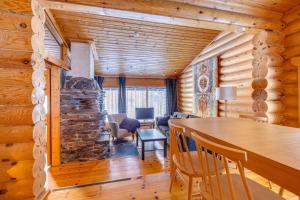 a dining room and living room in a log cabin at Holiday Apartment Lomalaavu D 2 in Suomutunturi