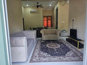 a living room with a couch and a rug at Homestay D'Bunohan in Tumpat