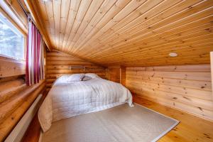 a small room with a bed in a log cabin at Holiday Apartment Lomalaavu D 2 in Suomutunturi