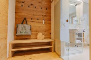 - une salle de bains avec un mur en bois et un lavabo dans l'établissement loisi's Boutiquehotel, à Achenkirch