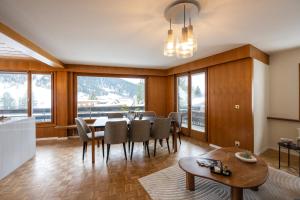 a dining room with a table and chairs and a large window at Chalet Alberti Davos Platz in Davos