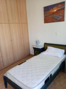 a bedroom with a bed and a painting on the wall at New apartment in Kallithea in Athens