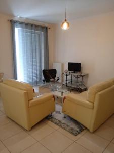 a living room with two chairs and a glass table at New apartment in Kallithea in Athens