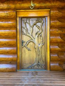 una puerta de madera con un árbol grabado en ella en Srub Čeladná, en Čeladná