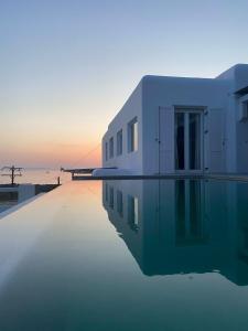 a house with a swimming pool in front of the ocean at Mykonian Luxury Villa Azure w Sea View and Pool in Agios Stefanos