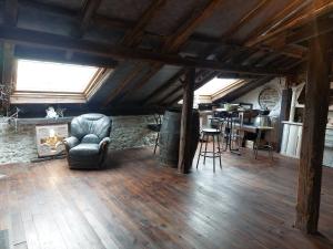 ein Wohnzimmer mit einem Stuhl und einem Tisch in der Unterkunft Chambres d'Hotes Les Hirondelles in Gaubiving