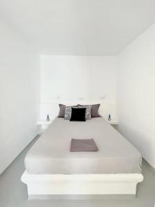 アギオス・ステファノスにあるMykonian Luxury Villa Azure w Sea View and Poolの白い壁の白い部屋のベッド