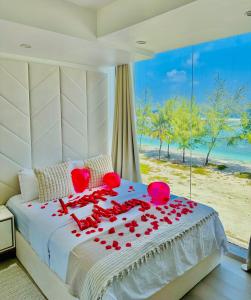 um quarto com uma cama com rosas vermelhas em Lazzlla beach front apartments em Hulhumale