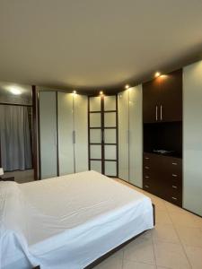 a bedroom with a large white bed and cabinets at PM 2 Via De Gasperi Guest House in Rozzano