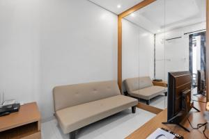 a living room with a couch and a television at Asasta Villa by Betterplace in Tabanan