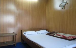 a bedroom with a bed with a cross on the wall at The Leo Homestay Cottage by StayApart , Buxa in Jayanti