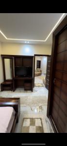um quarto com uma cama, uma televisão e uma porta em dreamland em ‘Ezbet `Abd el-Ḥamîd