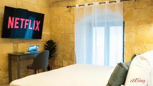 a bedroom with a netflix sign on the wall at A unique 400-year-old, modern Maltese home in Birgu