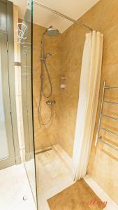 a bathroom with a shower with a glass door at A unique 400-year-old, modern Maltese home in Birgu