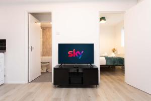 Modern flat - Sleeps 3 - London في انفيلد: وجود تلفزيون على منصة في غرفة المعيشة