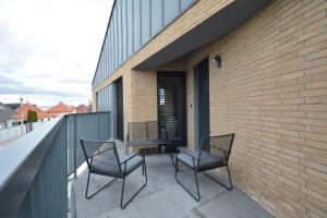 two chairs and a table on a balcony at Apartments Sered in Seredʼ