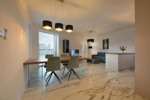 a dining room and living room with a table and chairs at Apartments Sered in Seredʼ