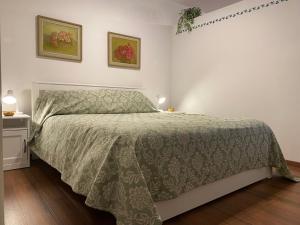 ein Schlafzimmer mit einem Bett mit einer grünen Bettdecke in der Unterkunft Appartamento Palazzo Montegnacco-Braida in Udine