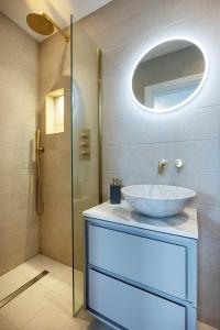 a bathroom with a sink and a mirror at Veeve - The Peace Lily in London