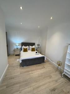 Luxury en-suite in modern house في Catford: غرفة نوم بسرير كبير وارضية خشبية